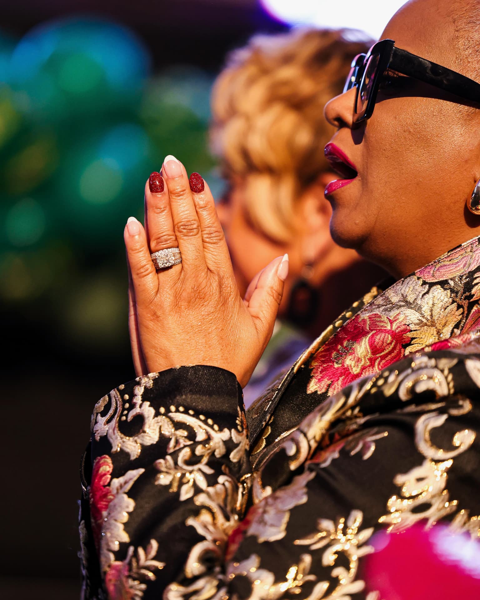 A woman praying with hands pressed together during service