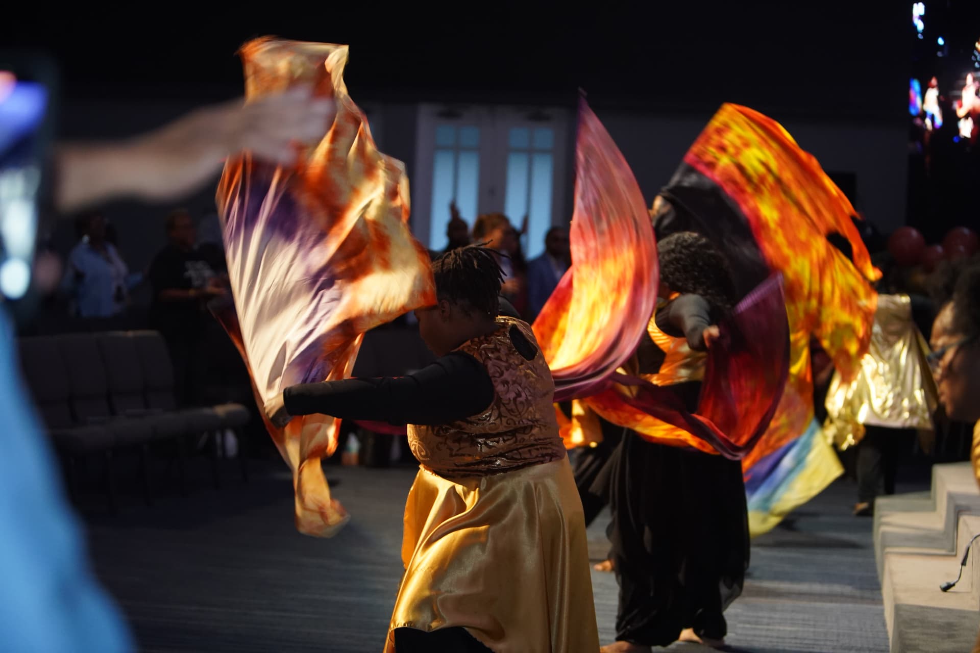 Worship dancers moving with vivid fire-colored flags