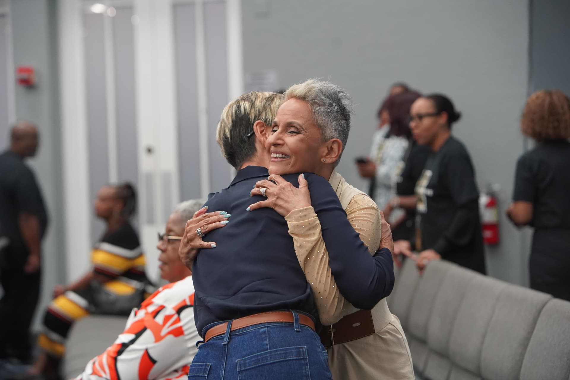 Two women embracing warmly between sessions