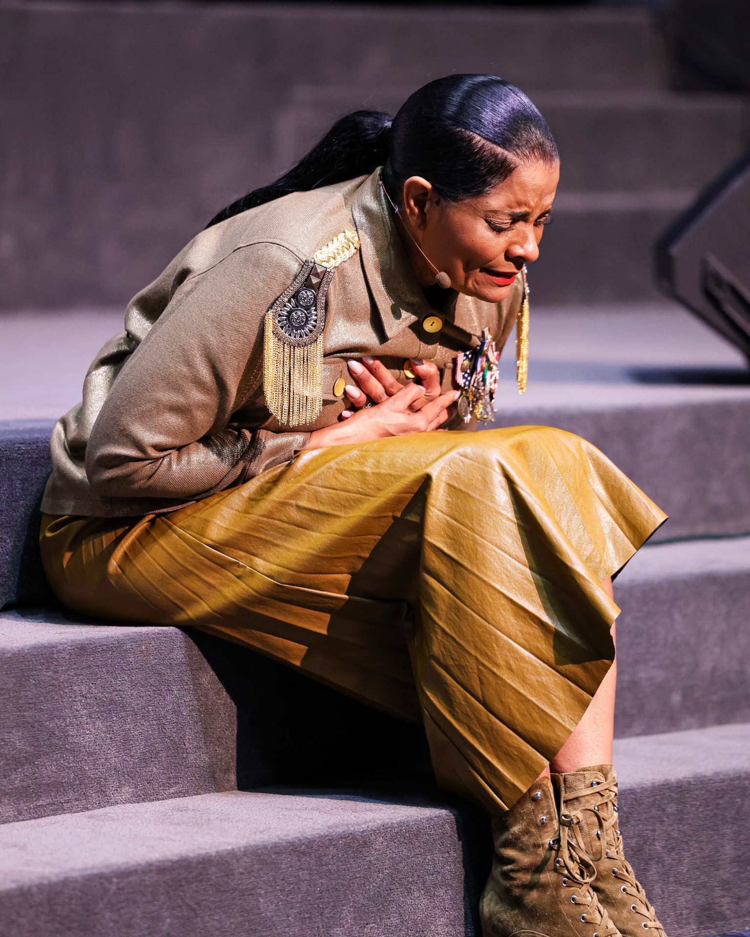 A speaker kneeling on the platform steps in prayer