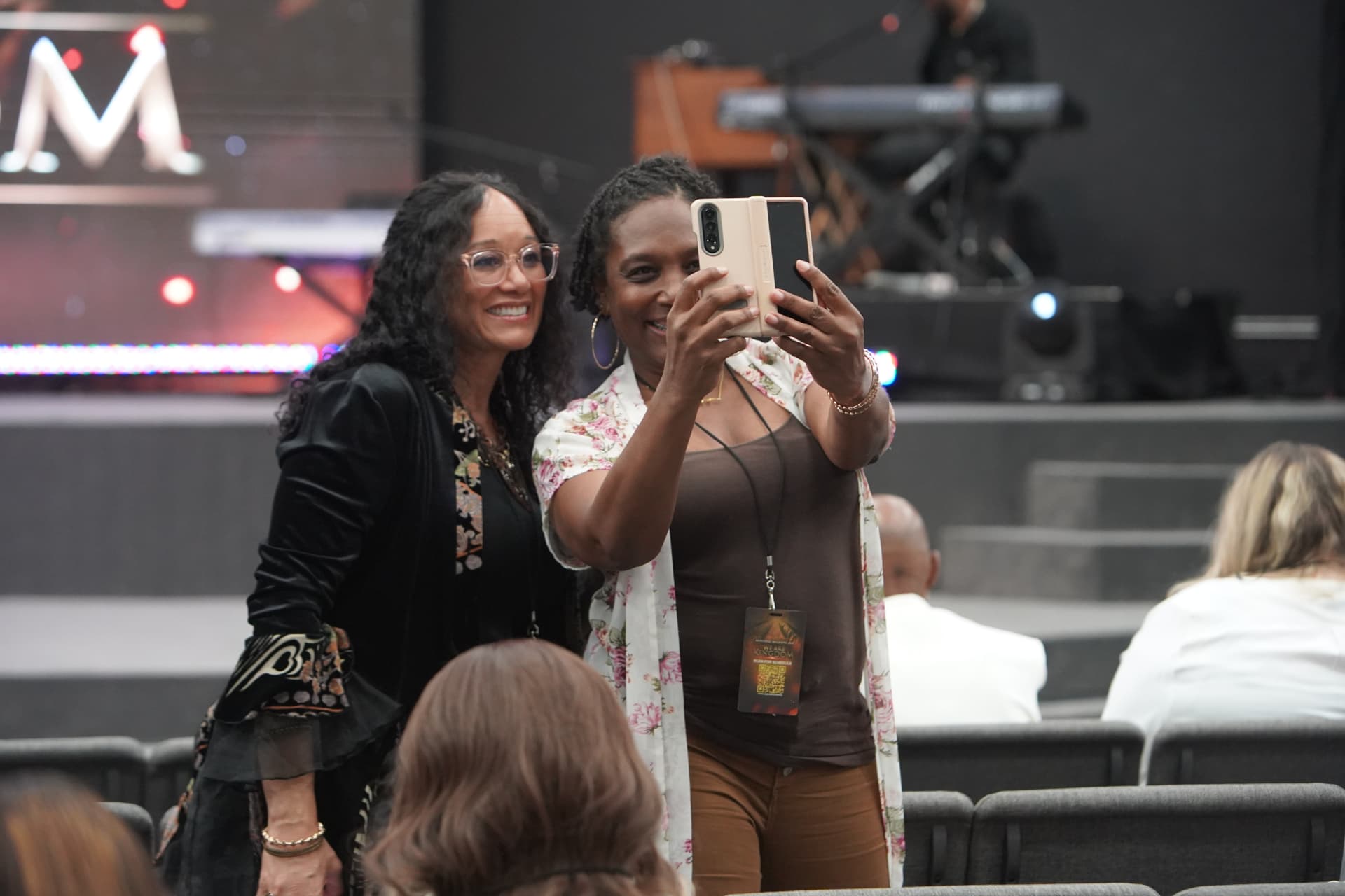 Two attendees smiling together for a photo in the sanctuary